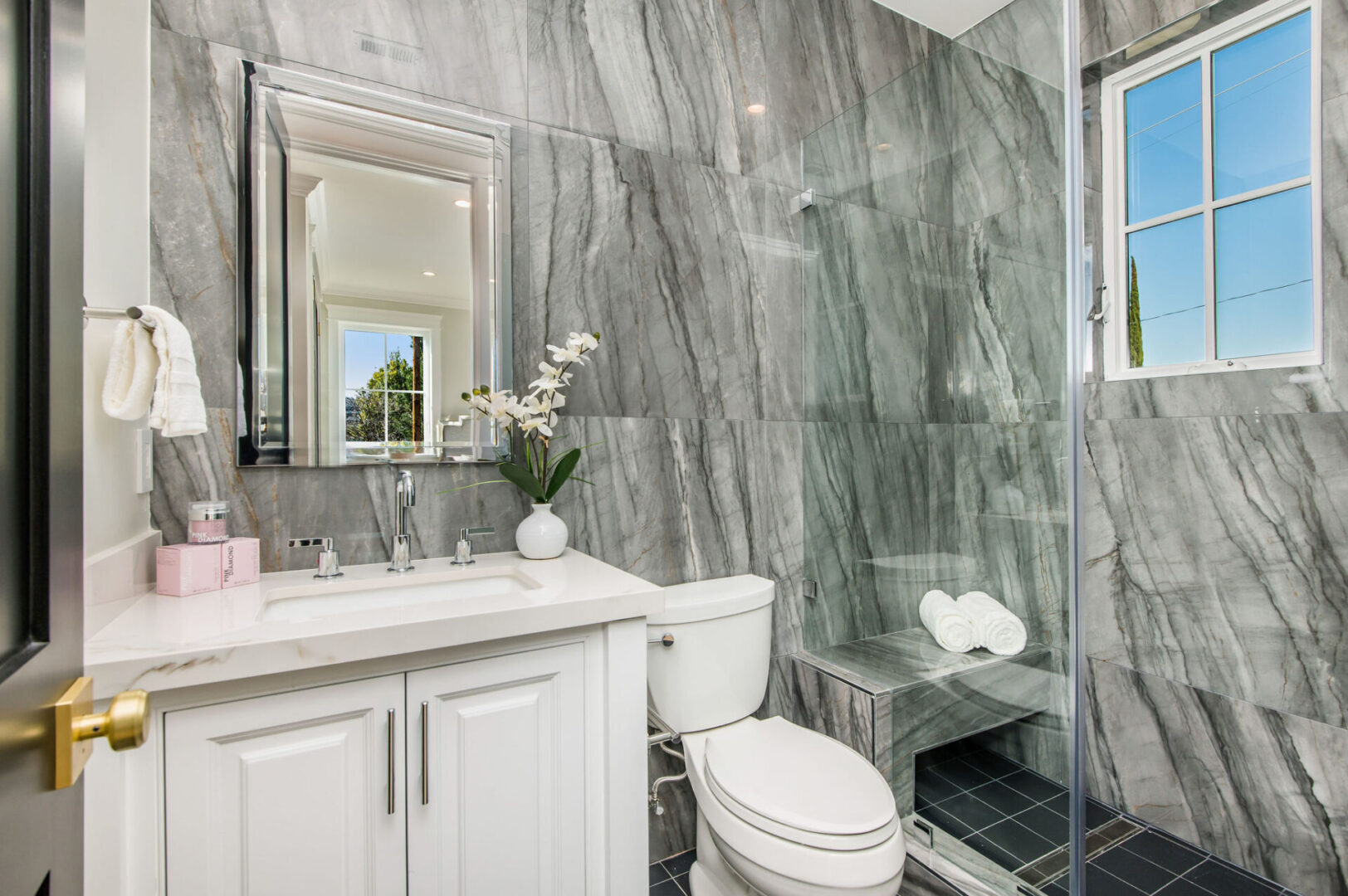 A Bathroom With Marble Wall and White SInk Counter