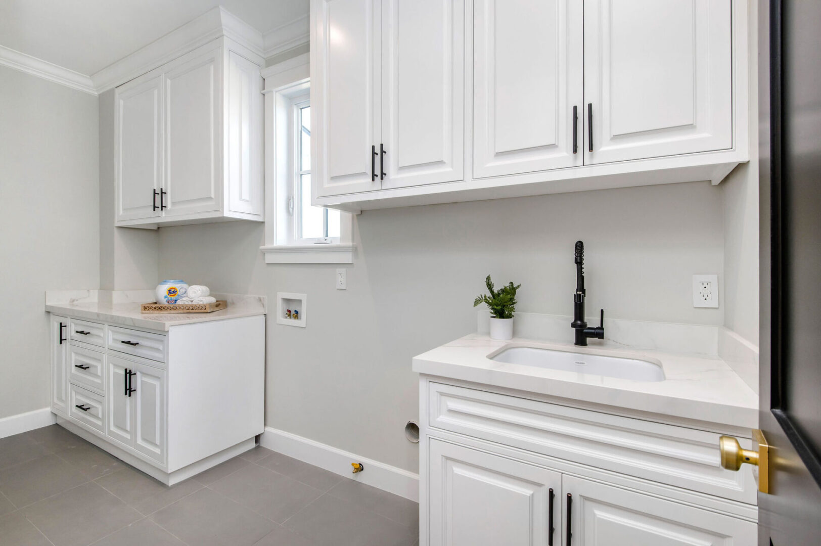 A White Color Cabinet With a Black Color Faucet