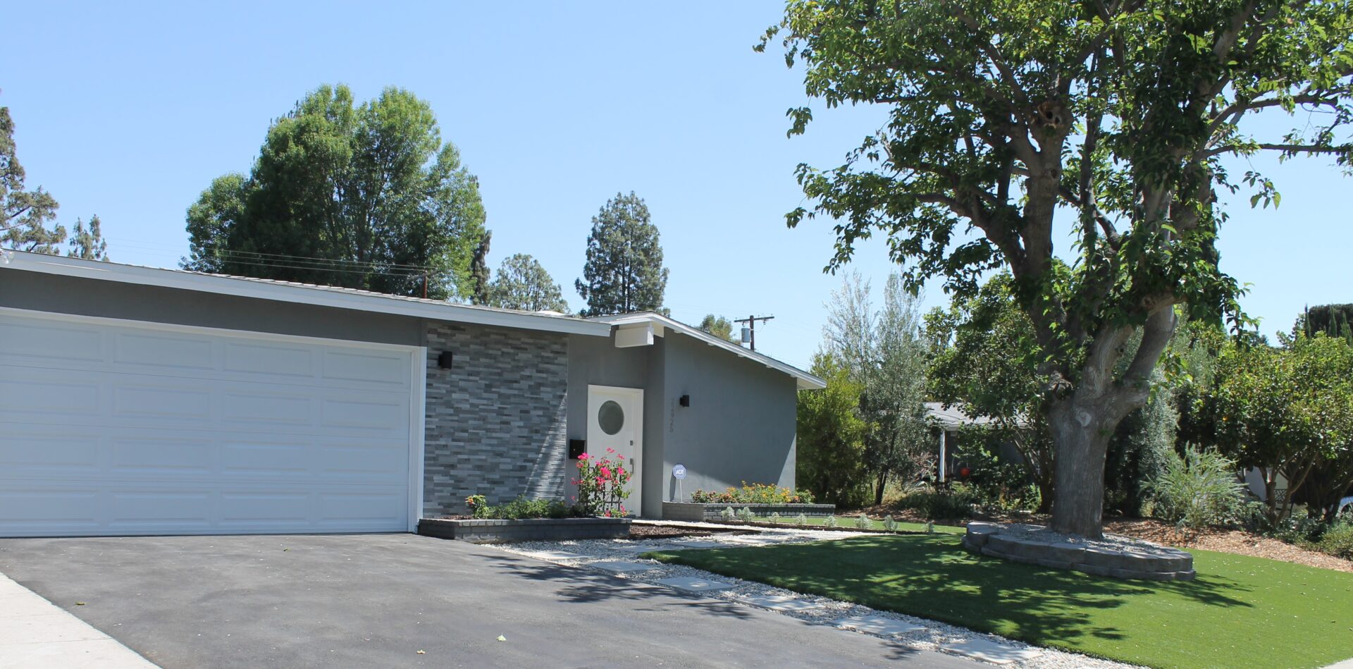 A Grey Color House With a White Shutter for a Garage